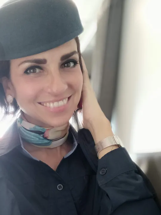 Larissa Belkis de uniforme da Azul, sorrindo dentro da aeronave.