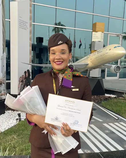 Larissa de uniforme da Etihad com o certificado de formação.