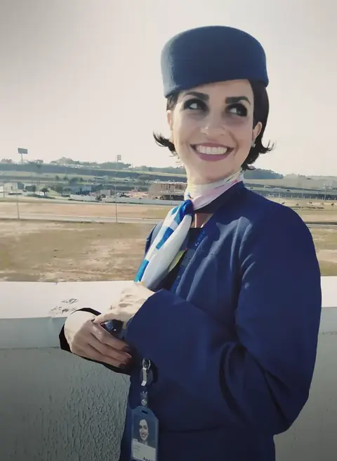 Larissa Belkis de uniforme da Azul, sorrindo no aeroporto.
