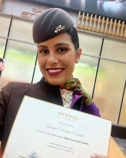 Géssica de uniforme da Etihad com o certificado de formação.